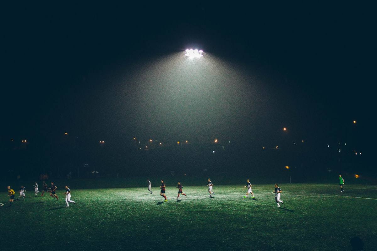 Lampu sorot stadion sepak bola saat senja